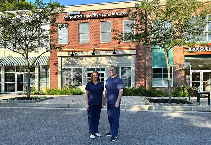 Gregory Kersh and Robin L. Steinberg are standing outside their brick clinic, smiling.